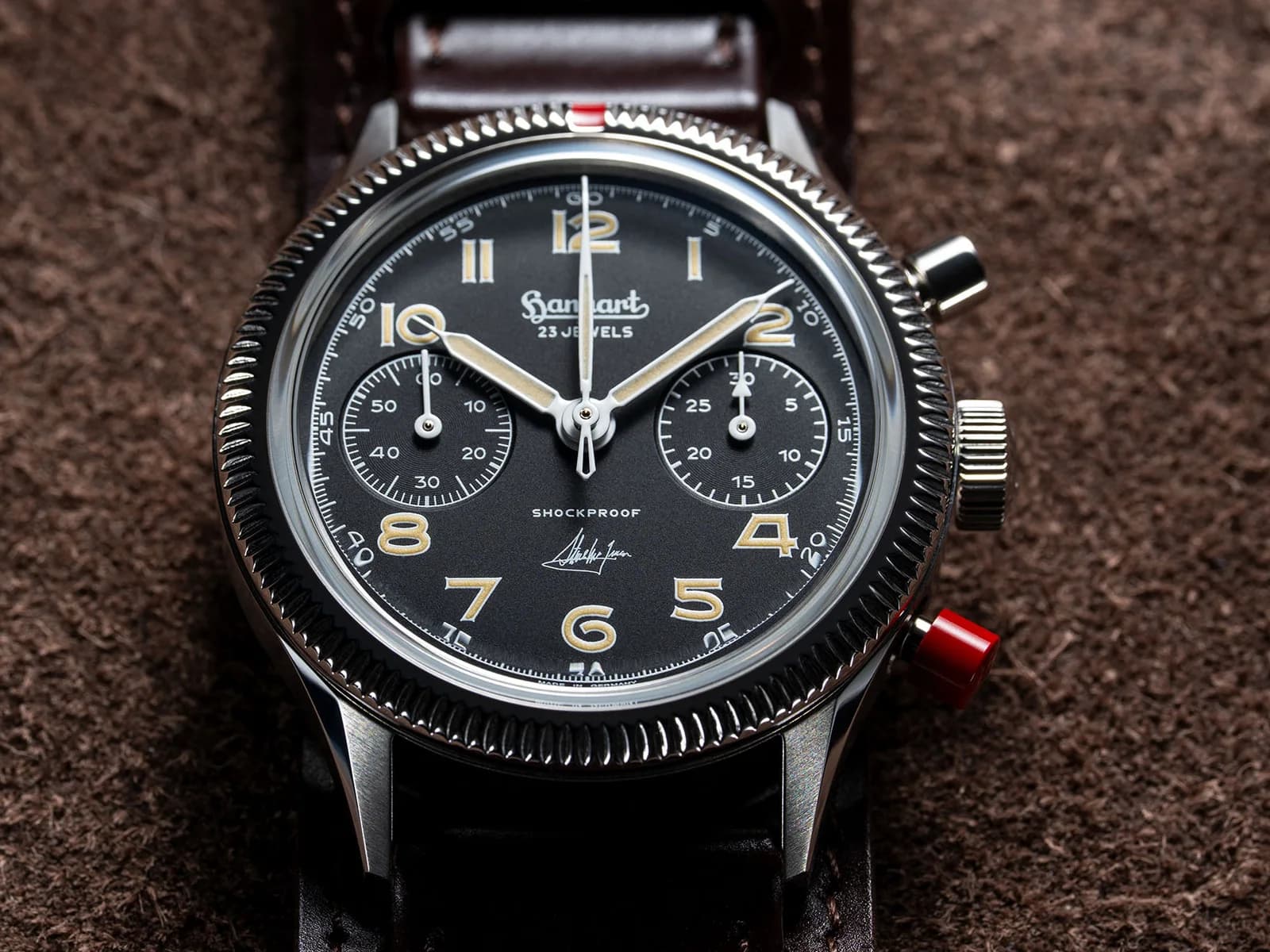 Nahaufnahme des schwarzen Hanhart-Zifferblatts mit zwei Hilfszifferblättern, Steve-McQueen-Signatur und rotem unteren Chronographendrücker.