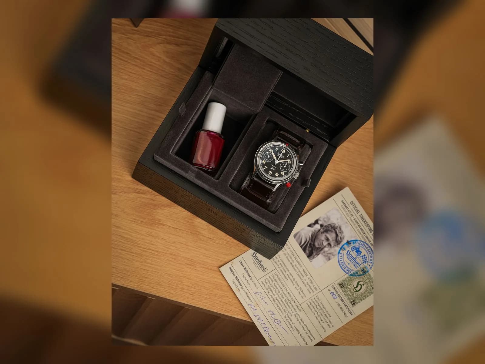 Geöffnete Hanhart-Uhrenbox mit der 417 ES, einer Flasche roten Nagellacks und der beiliegenden Limitierungskarte.